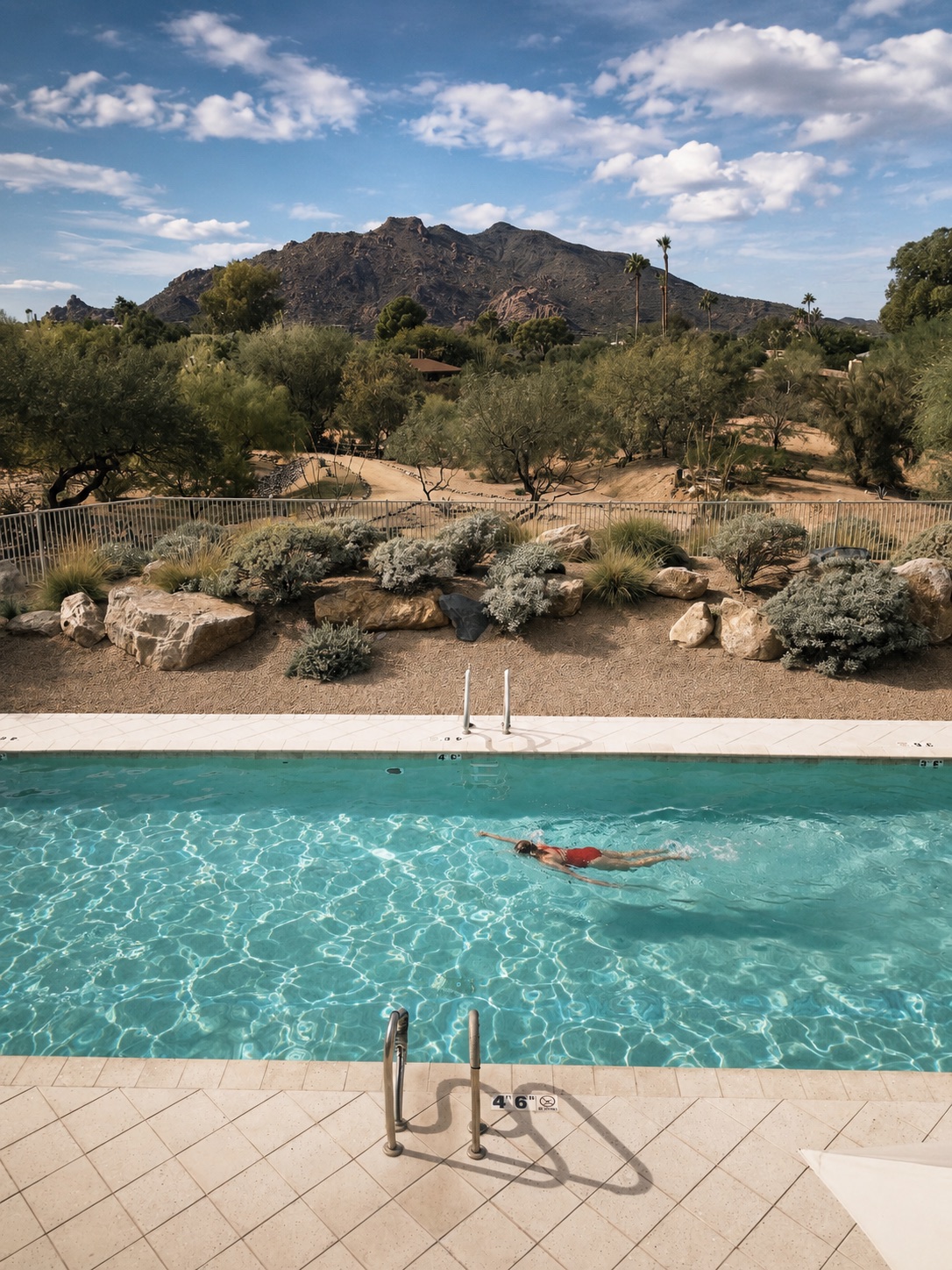 Guest swimming in an infinity pool at a desert resort at golden hour